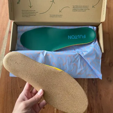 Customer holding a Fulton cork insole beside its open box